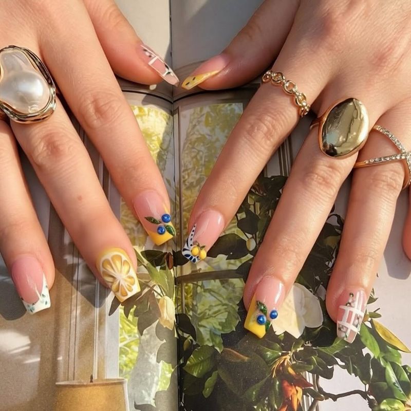 Nude nails with gold and floral accents by Nini Nail Bar
