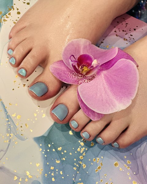 Pastel blue shimmer pedicure with a pink orchid by Nini Nail Bar