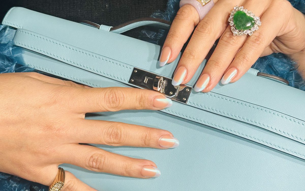 Two hands with nude almond nails and pale blue chrome French tips by Nini Nail Bar